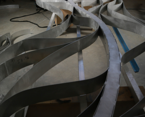 expertise_welding-mako-waves.jpg Welder works on wave sculpture for Mako Coaster